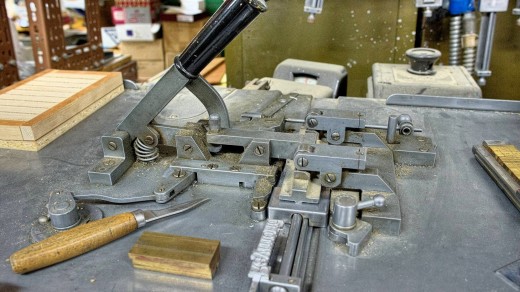 2015-01-18_0RA9471_v1_LTM_PC | The composing stick was then locked into the Ludlow machine as shown here. A lever on the front of the machine was then activated which injected typographic metal into the matrices to create a slug.